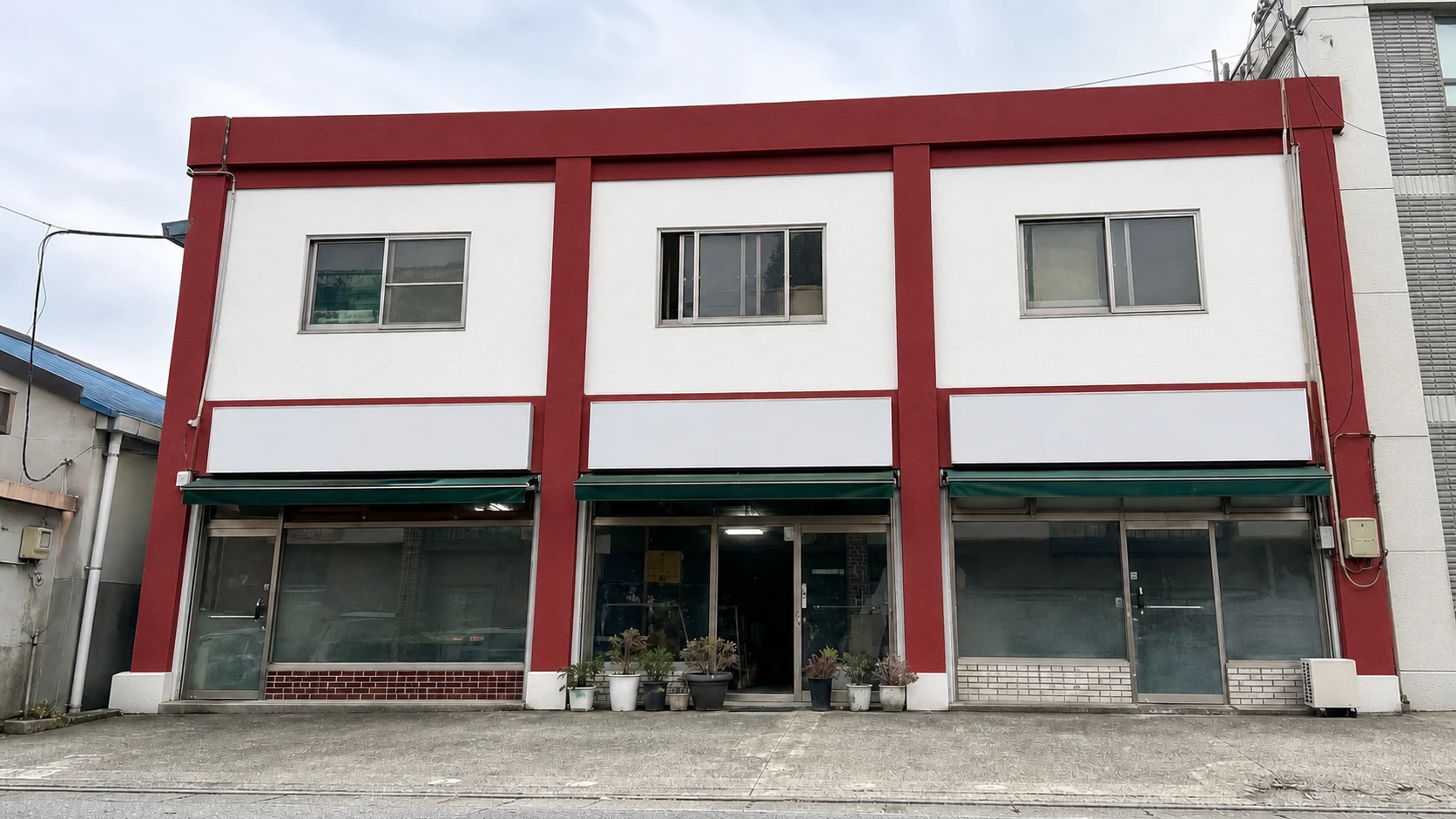 The same commercial exterior with clean white walls and red accent areas